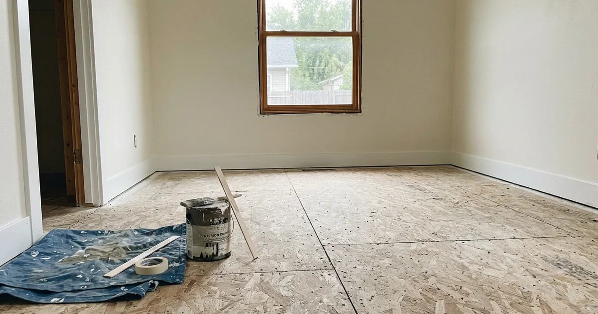 An empty, restored room with new subfloor exposed
