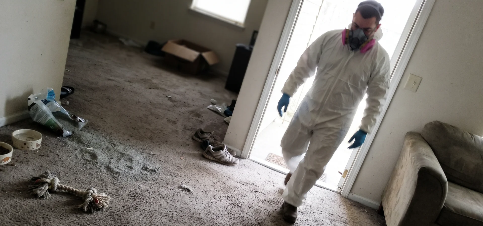Technician in respiratory protection entering a Cleveland home affected by animal hoarding